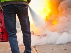 addetto antincendio durante l'utilizzo di un estintore per spegnere un incendio
